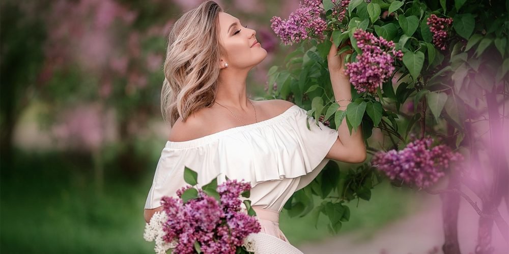 Beautiful blonde woman with lilac flower, Feminine Exercise | The Sublime Woman