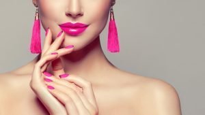 15 Ways To Replenish Your Feminine Energy woman with pink nails and lips pink earrings | The Sublime Woman
