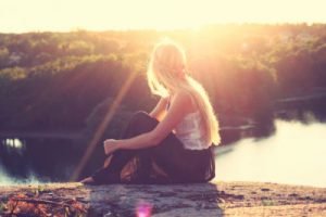How to stop energy loss young woman sitting on the shore| The Sublime Woman