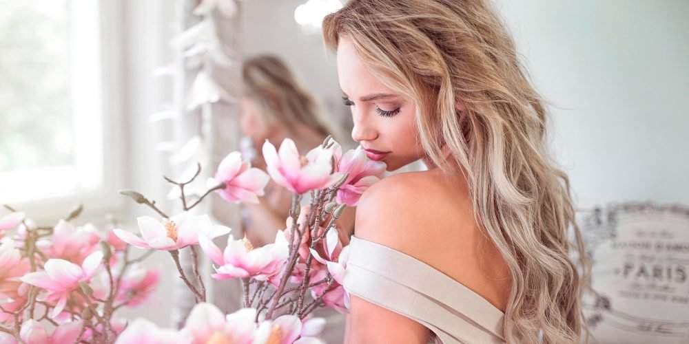 Woman holding beautiful pink flower feminine energy femininity | The Sublime Woman