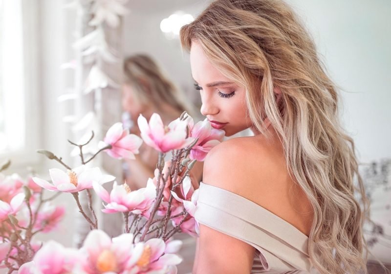 Woman holding beautiful pink flower feminine energy femininity | The Sublime Woman