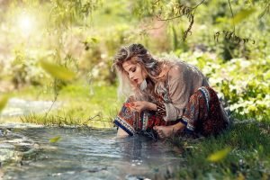Woman watching the water slavic blond beauty flowers in hair wise woman's energy secrets | The Sublime Woman