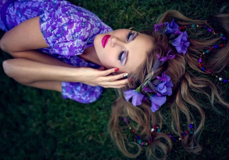 Practice Woman's Sahasrara Chakra Healing beautiful woman in violet laying on the earth with purple flowers | The Sublime Woman