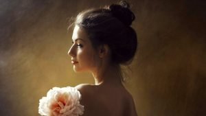 Feminine Stress Relief Stress and Femininity beautiful young woman smiling with a flower | The Sublime Woman