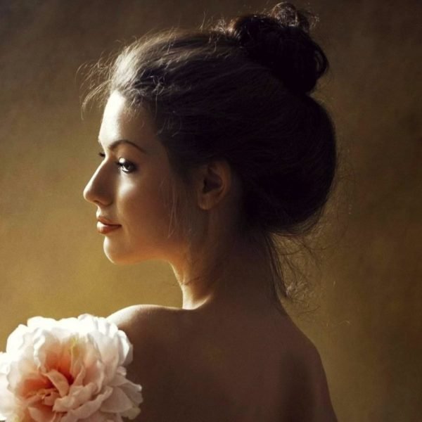 Feminine Stress Relief Stress and Femininity beautiful young woman smiling with a flower | The Sublime Woman