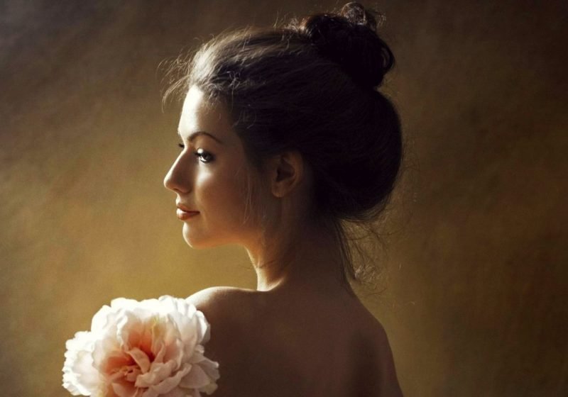 Feminine Stress Relief Stress and Femininity beautiful young woman smiling with a flower | The Sublime Woman