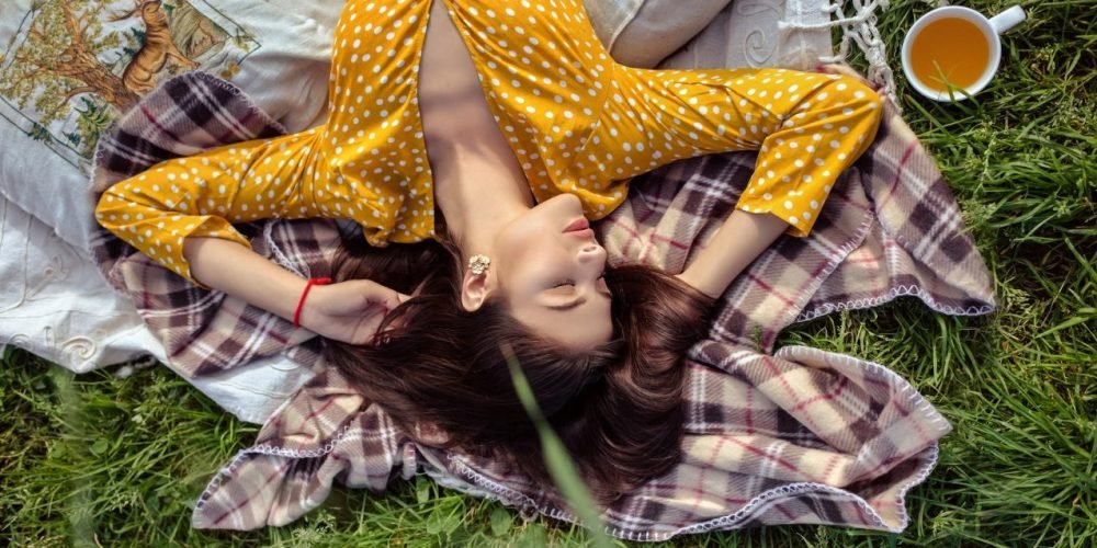 Dangers Of Woman's Desire To Help, Depletion From Too Much Helping, Beatiful Woman laying relaxing on Eart Green garss yellow dress, The Sublime Woman