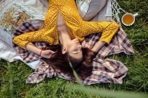 Dangers Of Woman's Desire To Help, Depletion From Too Much Helping, Beatiful Woman laying relaxing on Eart Green garss yellow dress, The Sublime Woman
