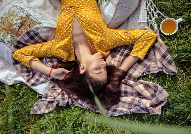 Dangers Of Woman's Desire To Help, Depletion From Too Much Helping, Beatiful Woman laying relaxing on Eart Green garss yellow dress, The Sublime Woman