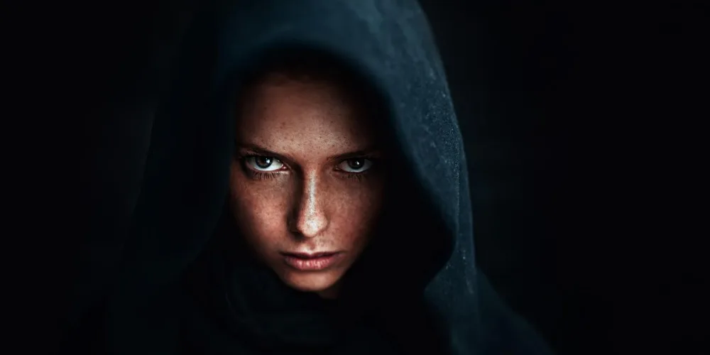 A mysterious woman in dark hood — symbolizing the dark feminine archetype