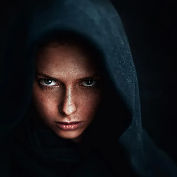 A mysterious woman in dark hood — symbolizing the dark feminine archetype