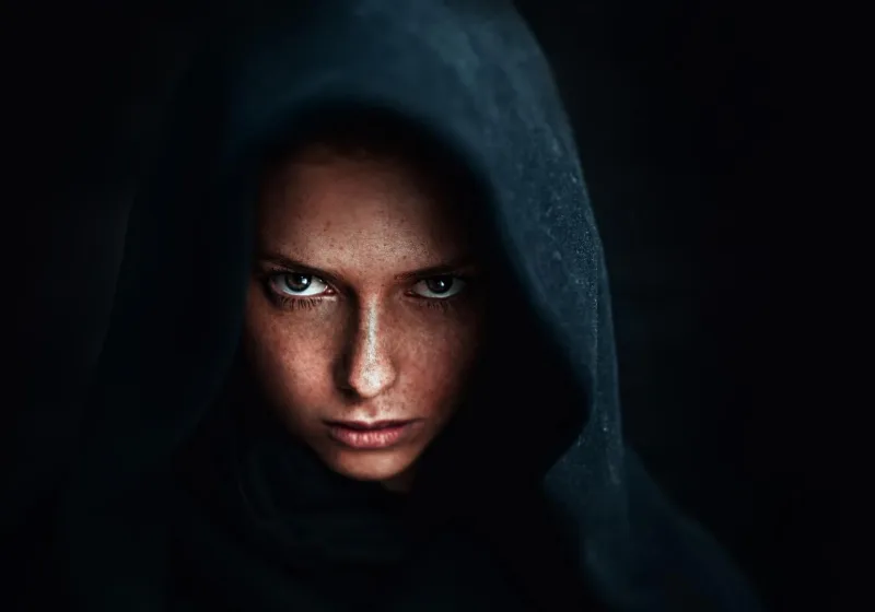 A mysterious woman in dark hood — symbolizing the dark feminine archetype